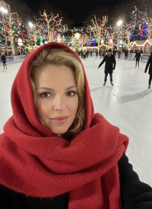 Woman in red scarf selfie at outdoor winter ice rink