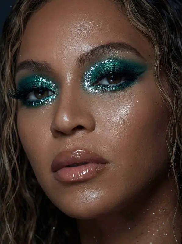 Close-up portrait of woman with dramatic emerald green glitter eye makeup