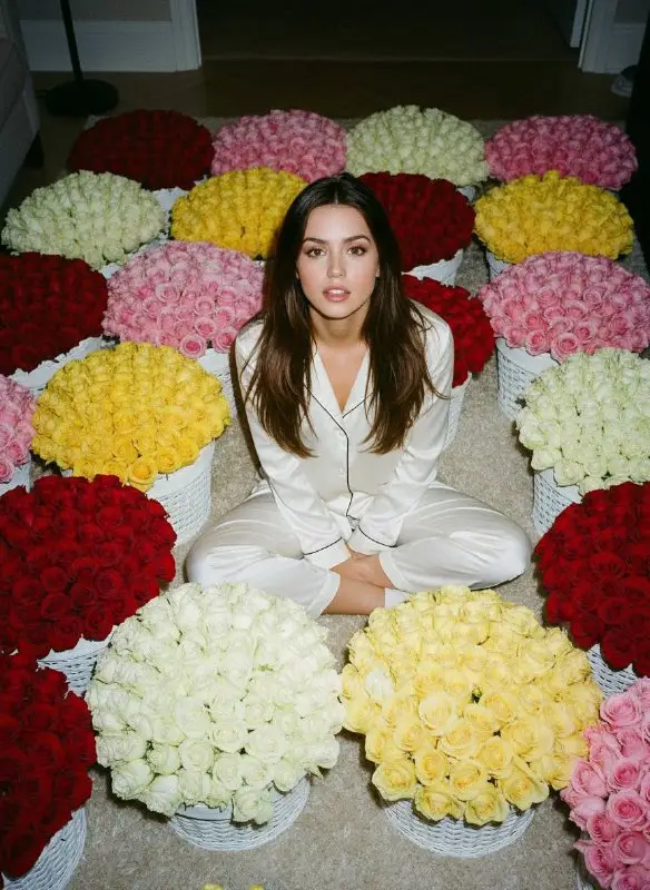 Woman in White Pajamas Surrounded by Baskets of Roses
