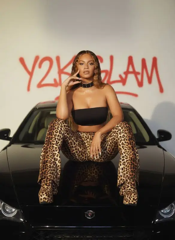 Stylish Woman in Leopard Print Outfit Posing on Black Car