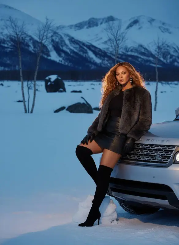 Stylish Woman Posing with Luxury Car in Snow Mountains