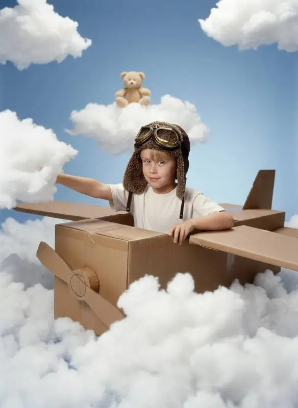 Young Boy Playing Pilot in Cardboard Box Airplane with Clouds