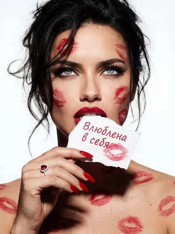 Woman with red lipstick kiss marks holding self-love note