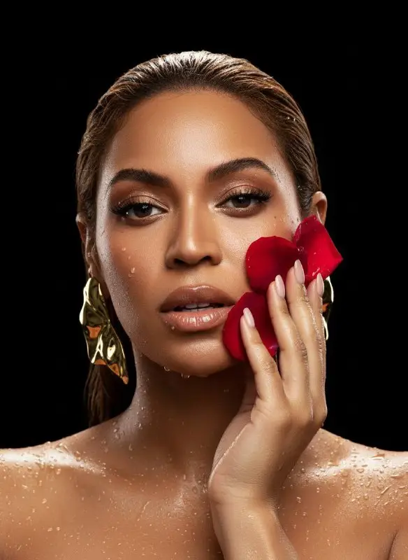 Elegant Woman with Wet Skin Holding Red Rose Petals