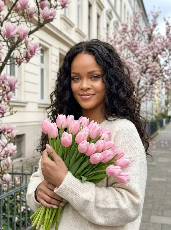 Beautiful woman holding pink tulips in a spring street portrait