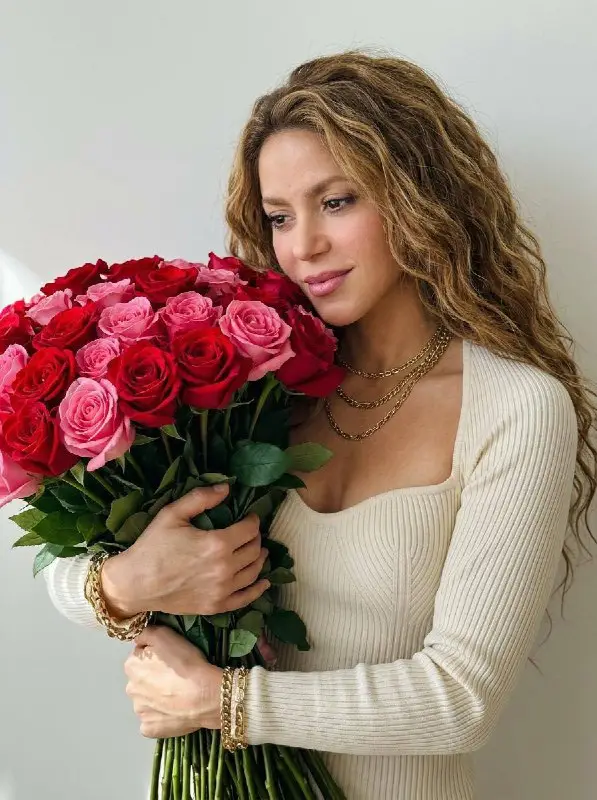 Beautiful woman holding a large bouquet of red and pink roses