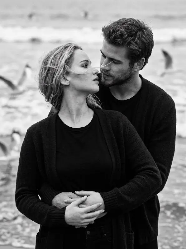 Romantic couple embracing on the beach in black and white