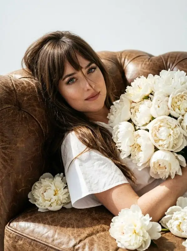 Elegant Young Woman Holding White Peonies on Leather Sofa